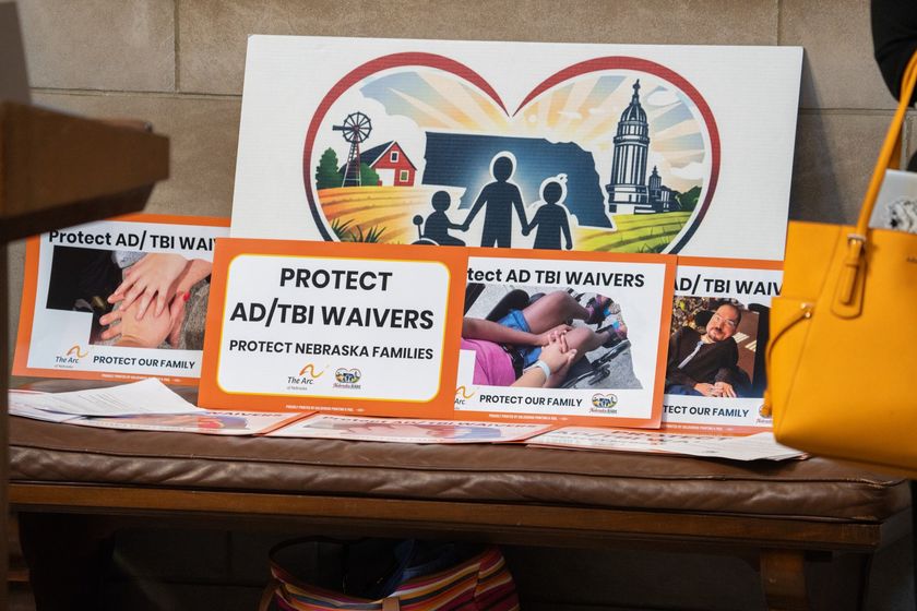 Signs urge the Nebraska Department of Health and Human Services to protect two Medicaid waivers for aging Nebraskans, those with disabilities and those who need care after a traumatic brain injury. Jan. 14, 2026. (Zach Wendling/Nebraska Examiner)